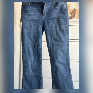 Blå jeansbyxor från ivy - Säljer ett par klassiska blå jeansbyxor med normal passform. Byxorna har en rak stil och är tillverkade i jeansmaterial. Perfekta för en avslappnad look. De är använda 1-2 gånger och köpta från thernlunds för 1200kr säljer för 800kr
