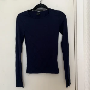 Mörkblå långärmad topp från Gina Tricot - Säljer en stilren mörkblå långärmad topp från Gina Tricot. Perfekt för lager-på-lager eller som den är. Enkel design som funkar till det mesta. 💙