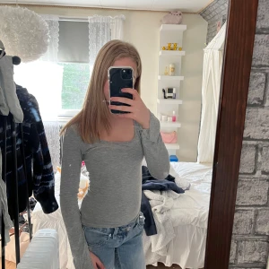 Grå tröja från Gina Tricot - Säljer denna gråa, urringade tröjan från Gina Tricot. Köpt här på Plick och använd 3-4 gånger av mig. Den är gjord av ett tunnt tyg och har snitt längst ut i ärmarna. Inga defekter. Säljer då den inte kommer till användning. Storlek XS 💕