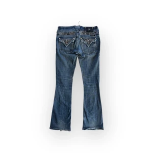Miss Me bootcut jeans - Midja 37, innerben 75. Storleken är W25 vilket psssar XS. De har sytts ut i midjan och en knapp på backtabben har lossnat men är i övrigt bra skick med lite lagningar.