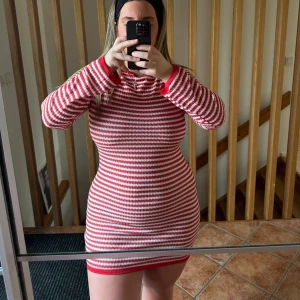 Röd- och vitrandig klänning - Säljer en snygg röd- och vitrandig klänning med lång ärm. Klänningen har en tight passform och är perfekt för en stilren look. Den är gjord i ett bekvämt material som passar bra till både vardag och fest.