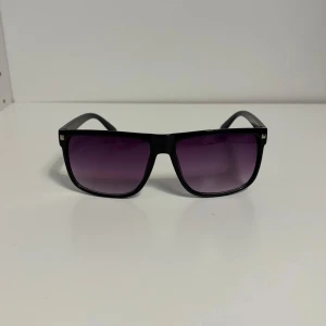 Solglasögon lika RayBan Boyfriend  - Snygga svarta solglasögon med fyrkantig form och lila tonade glas. Perfekta för en stilren look. Ramen är robust och ger en modern känsla.