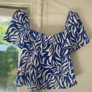 Blå och vit zebramönstrad topp - Säljer en blå och vit topp med zebramönster. Toppen har korta puffärmar och en fyrkantig urringning. Perfekt för en somrig look!❤️