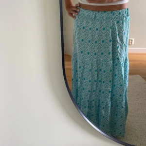 Turkos mönstrad långkjol - Jättefin långkjol med mönster! Jag var 165 cm på bilden. Köpt på Vinted men då va den ny med prislapp. Jag har använt den ungefär 5 gånger och säljer pga den är för kort för mig🩷