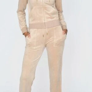 Beiga mjukisbyxor i velour - Supermjuka beiga mjukisbyxor i velour med dragsko i midjan och fickor både fram och bak. Perfekta för chill dagar och har en snygg, avslappnad passform. Matcha med hoodie för en komplett look.