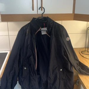 Moncler Vindjacka - Säljer en mörkblå vindjacka från Moncler. Inge kvitto finns kvar, Fler bilder kan skickas vid frågan.