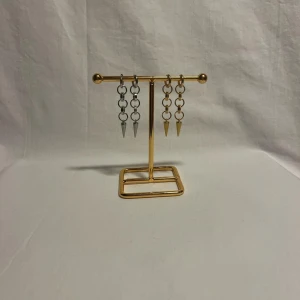 Chunky kedjeörhängen med spikes - Två par örhängen med chunky kedjor och spetsiga spikes. Ena paret är i silverfärg och det andra i guld. Båda har en edgy vibe och passar perfekt för dig som gillar statement-smycken. Säljs tillsammans.