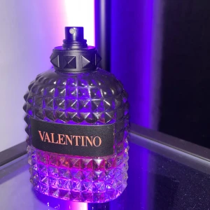 Valentino born in roma  - Säljer en lyxig parfym från Valentino i en cool, diamantmönstrad glasflaska med nitar på korken. Flaskan är transparent med en gradient från klar till bärnstensfärgad vätska och har en svart etikett med Valentino-logga i rosa. Perfekt för dig som gillar exklusiva dofter. Saknar kork tyvärr, ungefär 50ml kvar utav 100ml flaskan😁