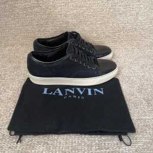 Svarta sneakers från Lanvin med lackad tå - Snygga svarta sneakers från Lanvin med ovandel i mocka och en glansig lackad tå. Dem är i storlek uk 6 vilket motsvarar 41-42.nypris ligger runt 4999kr