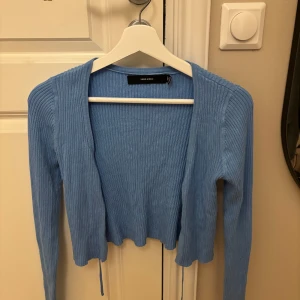 Blå ribbad kofta från Vero Moda - Säljer en ljusblå ribbad kofta från Vero Moda i storlek S. Koftan är croppad med långa ärmar och har en öppen front med tunna knytband. Koftan är kort i modellen. Aldrig använd, alltså inga skador💓Köparen står för frakten
