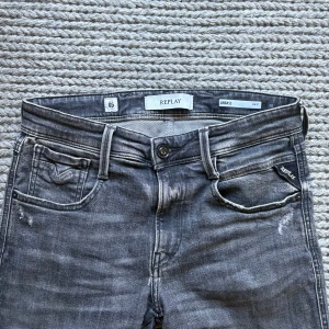 Replay Anbass  - Gråa Replay Anbass med slitningar och en snygg wash, Sitter slim! W 30 L 32. 37x2 cm i midjemått och 103 cm i längd (hela benet från midjan!) nästan helt oanvända med lapp kvar. Mycket eftertraktade!