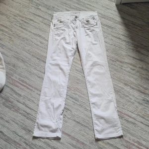 Vita byxor från ConBlue med detaljer - Snygga vita byxor med  lite flare och coola detaljer som dekorativa knappar vid fickorna och broderade bakfickor. Byxorna är i sotrlek XS och är tillverkade i bomull, vilket gör dem både bekväma och stilrena. De har inte används mycket alls som gör att de är I mycket gott skick. Pris går såklart att diskuteras! 🎀