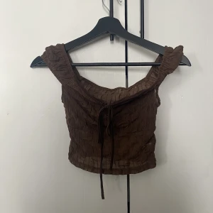 Brun top - Denhär toppen är så otroligt snygg! Snygga ärmar och knytdetaljer. Det är också möjligt att välja om man vill ha offshoulder eller inte😊  Säljer då den tyvärr blivit för liten för mig.