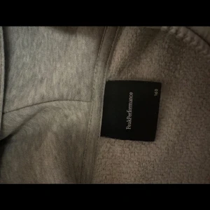 Grå Peak Performance hoodie med dragkedja - Snygg grå hoodie från Peak Performance med huva och dragkedja framtill. Tröjan har två fickor, ribbade muddar och svart logga på bröstet. Passar 160 som är Ish xs/s användes inte så mycket, bra skick! Skriv vid funderingar! Pris kan diskuteras 