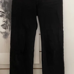Svarta high waist jeans från Weekday - Säljer ett par svarta high waist jeans från Weekday, modell Voyage high straight. De har raka ben och klassisk femficksdesign. Jeansen är i bomull och har en snygg, enkel look som passar till allt.