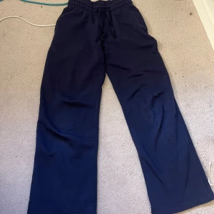 Mörkblå mjukisbyxor från Gina Tricot xxs - Mörkblå mjukisbyxor från Gina Tricot, basically basics-kollektionen. Byxorna har resår i midjan med snörning och raka, lite vidare ben. Tillverkade i mjukt bomullsmaterial som är skönt mot huden. Använda fåtal gånger.