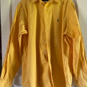 Gul skjorta från Ralph Lauren - Säljer en gul skjorta från Ralph Lauren. Hör av dig vid frågor, priset kan diskuteras.  🧵 Skick: Mycket bra 9/10 📏 Storlek: L 🎨 Färg: Gul 🏷️ Märke: Ralph Lauren