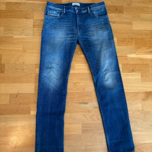 Blå jeans från Stone Island - Snygga blå jeans från Stone Island med klassisk femficksdesign och ikonisk badge på bakfickan. Jeansen har en rak passform och är tillverkade i mjukt bomullstyg med lätt slitning! Storlek är 32/32. Lådan kommer med om man vill hämta jeansen. *pris ej ristat i sten