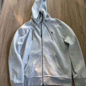 Grå zip Ralph Lauren - Ljusgrå kofta. Inga fläckar eller andra spår av skada.
