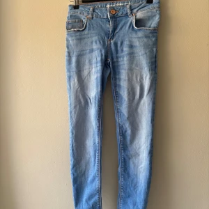 Ljusblå skinny jeans XS  - Blå jeans, uppsydda så de ska passa längden 152cm, kan behöva sys på nytt pga en liten del av söm lossnat, se bild. Dock inget som påverkar.  Från sida till sida vid öppningen : 33cm