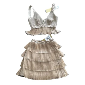 Beige topp och kjol med fransar från PatBO - Säljer ett fantastiskt tvådelat set bestående av en cropped topp (storlek 0) och en minikjol (storlek 2). Topp med metalliskt fransdetalj och dragkedja bak. Kjolen har hög midja, lager av fransar och en dold dragkedja bak. Nypris: $975 USD. Ett riktigt statement-plagg för fest eller sommarens events!