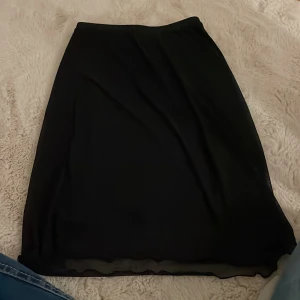 Svart kjol från H&M - Snygg svart kjol från H&M i en klassisk design. Perfekt för olika tillfällen och lätt att matcha med olika toppar. Kjolen har en enkel och stilren look.