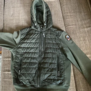 Grön jacka från Parajumpers - Säljer en snygg cardigan från parajumpers den är i mycket bra skick med bara en liten fläck på baksidan som inte är synlig  