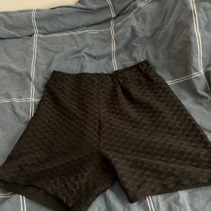 Svarta shorts med textur - Snygga svarta shorts med en unik textur. Perfekta för en avslappnad stil. De har en elastisk midja för extra komfort.