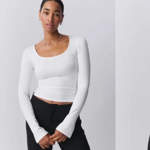 Vit långärmad topp - Snygg och stilren vit långärmad topp med rund halsringning och en liten slit i armarna längst ner. Super fin. Skriv för mer bilder.