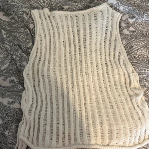 Vit stickad väst med snörning 🤍 - Säljer en vit stickad väst med ett unikt randigt mönster. Västen har en snygg snörning på sidan som ger en cool look. Perfekt för att lägga till en extra touch till din outfit! Älskar 🤍