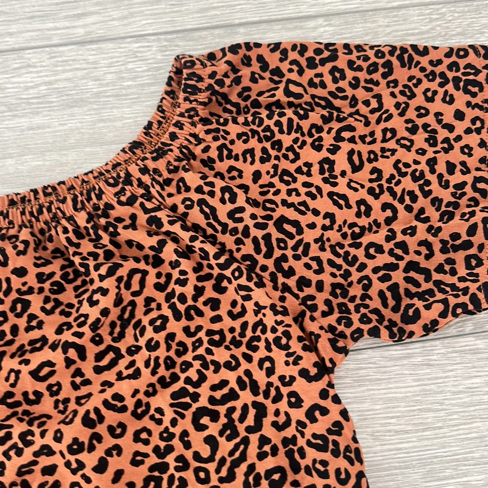 Snygg leopardmönstrad offshoulder topp från Lindex i en härlig brun nyans. Toppen har korta ärmar och knappar framtill, vilket ger en trendig look. Perfekt för att sticka ut i mängden!. Yläosat.