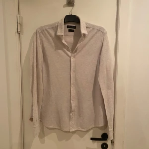 Beige skjorta från Massimo Dutti - Säljer en stilren beige skjorta från Massimo Dutti. Skjortan har långa ärmar och knappar framtill. Perfekt för en elegant look. Passar M bra. Skönt material!