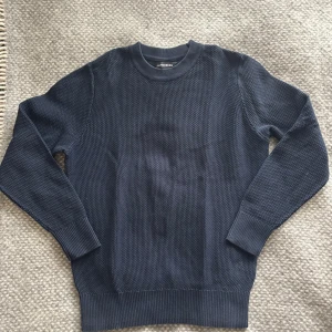 Mörkblå stickad tröja från J.Lindeberg - Säljer en stilren mörkblå stickad tröja från J.Lindeberg. Tröjan har en rund hals och långa ärmar med ribbade muddar. Använd fåtal gånger! Skicka ett pm vid intresse!|nypris:840kr|storlek S|