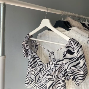 Zebramönstrad blus med puffärmar - Trendig zebramönstrad blus med puffiga kortärmar och knytning framtill. Jättefin blus till sommaren. Kontakta gärna för fler bilder☺️☺️