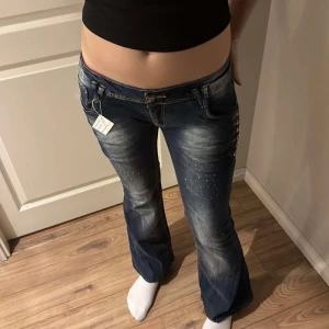 Lowrise bootcut jeans - Omsydda Lågmidjade bootcut jeans med glitterstenar  Grenhöjden: 17 cm Midjemått: 41,5 cm Innerbenslängden: 76cm