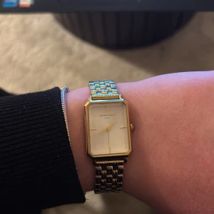 Guldfärgad klocka från Rosefield - Elegant guldfärgad klocka från Rosefield med rektangulär urtavla och stilren design. Armbandet är i metall med en klassisk länkstil som ger en tidlös look. Perfekt för att lyfta vilken outfit som helst. Nypris 1415 säljes för 450 aka mer än 60 % off👐 Säljes pga insett att jag är en silvertjeja men för mina guldbabes är denna klockren🫶🏻Frakt tillkommer