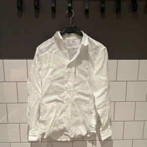 Vit linneskjorta från Uniqlo - Säljer en stilren vit linne skjorta från Uniqlo i storlek XS. Skjortan har alla lappar kvar på sig aldrig använd. 