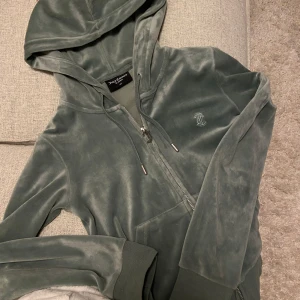 Grön velour hoodie från Juicy Couture - Mysig grön velour hoodie från Juicy Couture med dragkedja och huva.