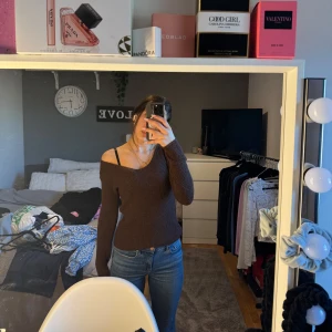 Brun offshoulder tröja - Säljer en snygg brun offshoulder tröja med lång ärm. Perfekt för en stilren look. Tröjan har en ribbad struktur som ger en skön passform. Passar bra till jeans eller kjol för en avslappnad stil.