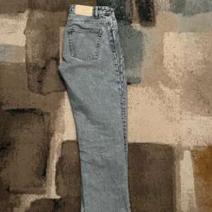 Grå jeans från Zara - Snygga grå jeans från Zara med en klassisk straight fit. De har en traditionell femficksdesign och stängs med knappar. Perfekta för en stilren look.30/30