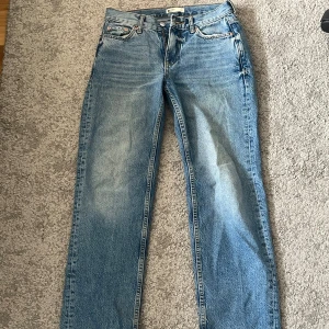 Blå lågmidjade jeansbyxor 32 - Klassiska blå jeansbyxor lågmidjade med en rak passform. Byxorna har en traditionell femficksdesign och är tillverkade i slitstarkt denim. Perfekta för en avslappnad stil. Från Gina Tricot i storlek 32