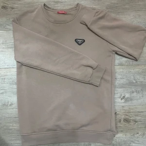 Prada Tröja - Snygg beige Prada tröja i storlek M, har använts ett par gånger men annars är tröjan i bra skick