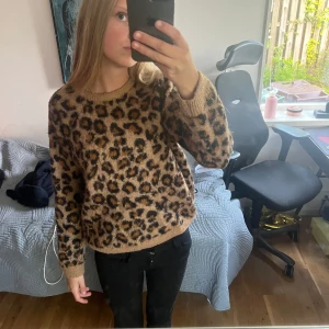 Leopardmönstrad stickad tröja från H&M - Säljer en snygg stickad tröja från H&M med leopardmönster i bruna och svarta toner. Tröjan har rund halsringning och långa ärmar. Perfekt för dig som vill sticka ut lite extra i höst och vinter!