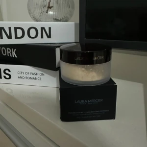 Laura Mercier Translucent Loose Setting Powder - Translucent Loose Setting Powder från Laura Mercier. Ett löspuder i transparent nyans som ger en matt finish och fixerar sminket. Kommer i en rund burk med svart lock och tillhörande kartong. Den är oöppnad 