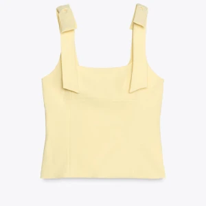 Zara populär gul topp  - Söt ljusgul linnetopp med breda axelband som knyts i rosetter på axlarna.  Aldrig använd har fortfarande prislappen på