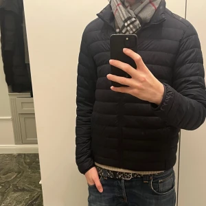 Mörkblå dunjacka från Uniqlo - Säljer en stilren och lätt mörkblå dunjacka från Uniqlo. Inga defekter,skriv om du är intresserad.