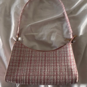 Rosa väska  - Säljer en söt väska i rosa och vitt mönster med lite glitter. 