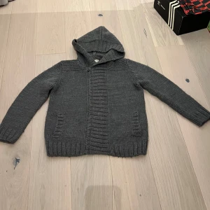 Cardigan  - En fodrad cardigan med luva som funkar i alla väder.Storleken är 13-14 år men jag har XS och den är för stor alltså storlek S.Bra skick,ställ gärna frågor och skicka prisförslag.