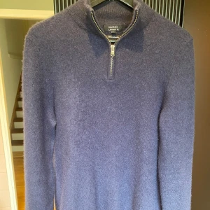 Mörkblå kashmir halv zip  med dragkedja från Galeries Lafayette - Säljer en exklusiv mörkblå tröja i 100% kashmir från Galeries Lafayette. Tröjan har halv dragkedja vid halsen och lång ärm. Perfekt för dig som vill ha något både stilrent och mjukt.  Står L men passar S