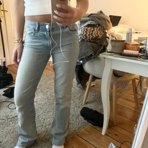 Ljusblå bootcut jeans - Säljer ett par ljusblå jeans med bootcut passform och klassisk femficksdesign. Jeansen har låg midja och är tillverkade i ett mjukt denimtyg. Perfekta för en avslappnad och trendig look.